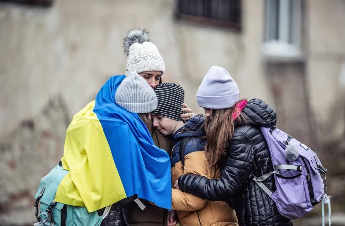 vrouw met drie kinderen in tranen en in puin