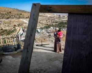 Palestijnse vrouw met baby bij haar afgebroken huis