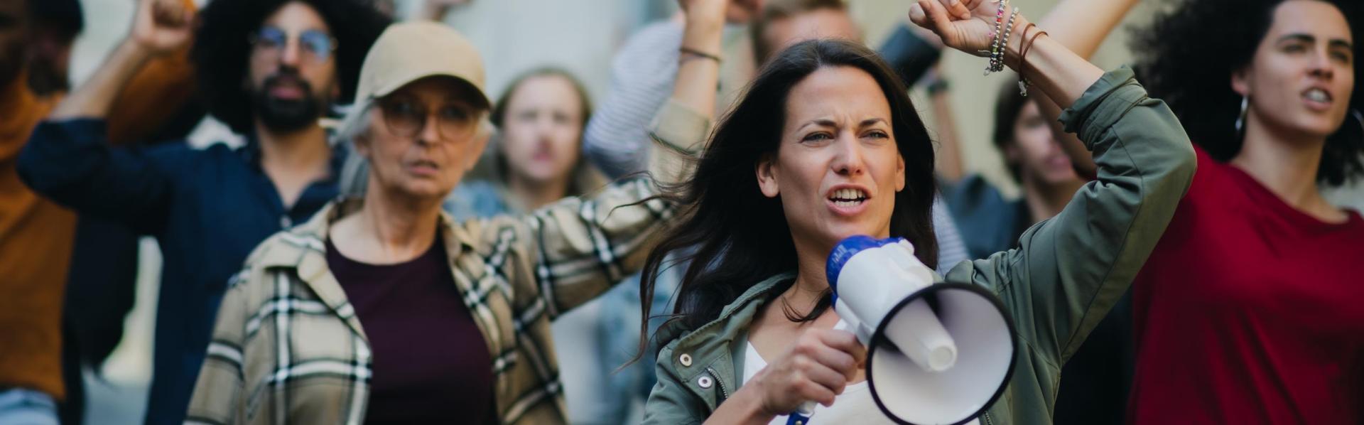 groepen mensen die protesteren met handen in lucht en microfoon