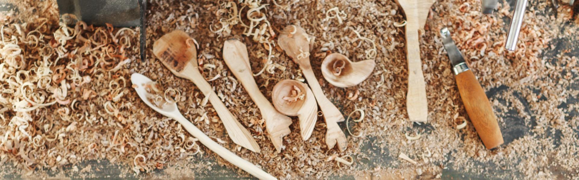 Een man aan het werk met houtsnij-instrumenten.