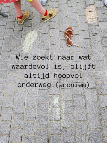 Kindervoeten met krijt getekend op een stenen pad. Er staat ook een sandaaltje tussen. Bovenaan zien we kleurrijke kinderbenen.