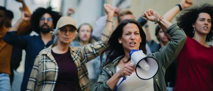 groepen mensen die protesteren met handen in lucht en microfoon