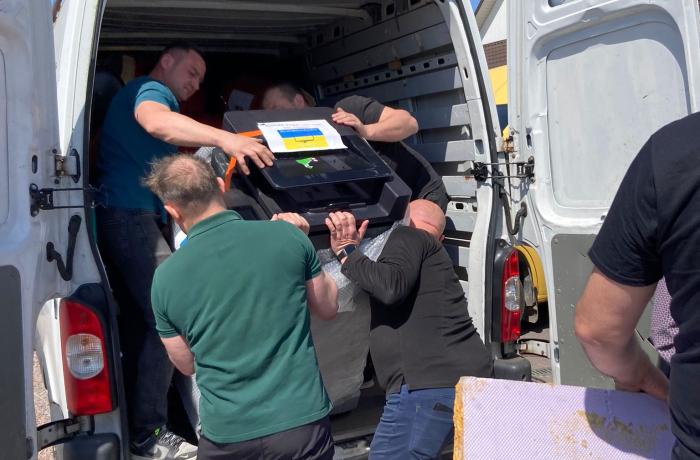 materiaal omladen in de busjes van het konvooi