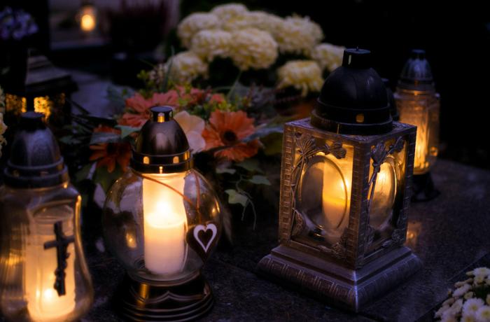 Kaarsen en bloemen staan op een graf
