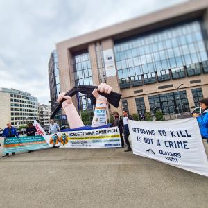 manifestanten met opgeblazen gebroken geweer voor gebouw van Europese Raad